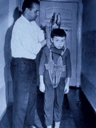 Boy in a harness about to be lowered from a building over the Wall